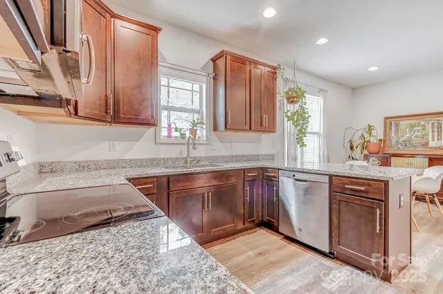 a kitchen with stainless steel appliances granite countertop sink stove and granite counter top