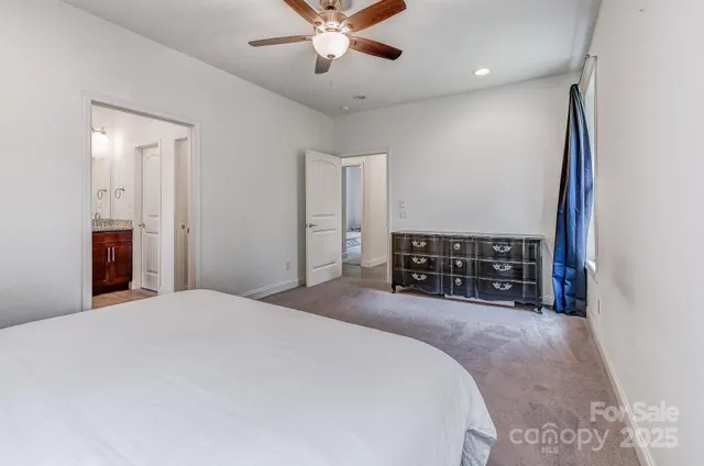 a spacious bedroom with a bed and a ceiling fan