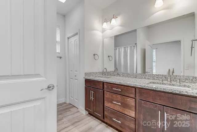 a bathroom with a granite countertop sink a mirror and a shower