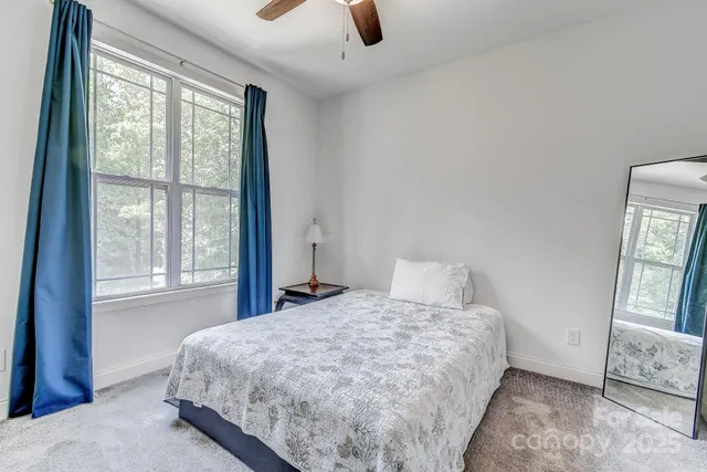 a bed sitting in a bedroom next to a window
