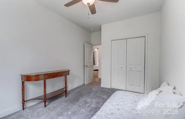 a bedroom with a bed and a chandelier fan