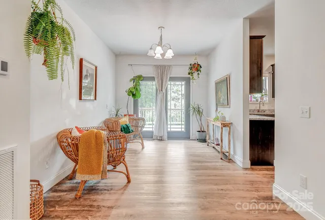 a dining room with furniture a chandelier and wooden floor