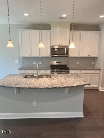 a kitchen with a sink stove and refrigerator