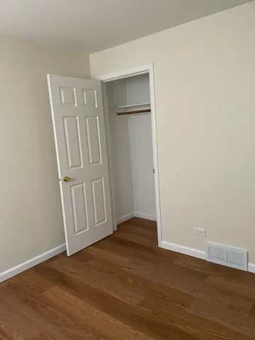 a view of a room with wooden floor and a bathroom