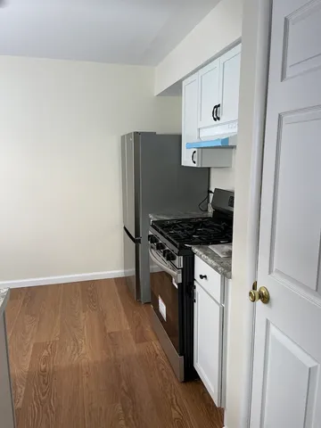 a kitchen with stainless steel appliances granite countertop a stove a refrigerator and a cabinets