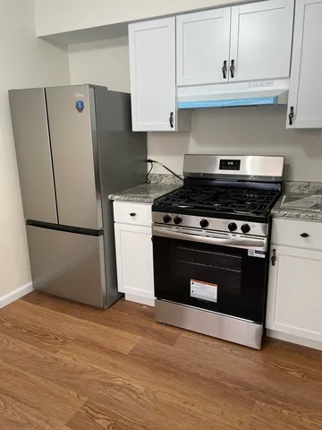 a view of a refrigerator in kitchen and wooden floor