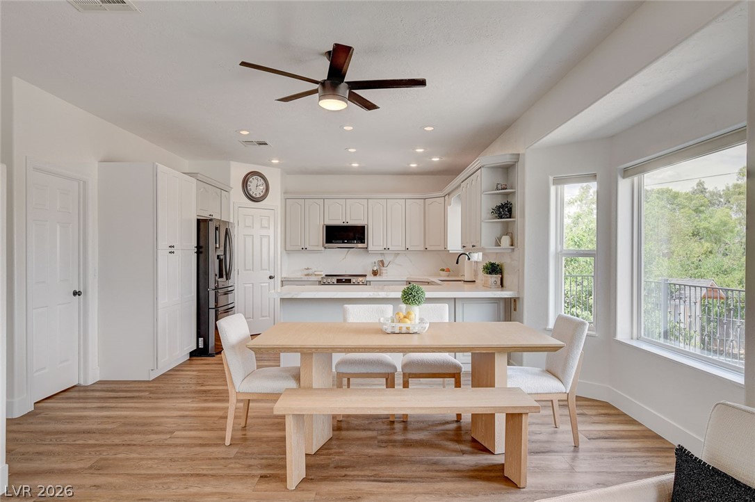 4362 Thistle Street Logandale, NV 89021 - Photo 20 of 99 Natural light bathes this open-concept kitchen and dining area with durable wood flooring.