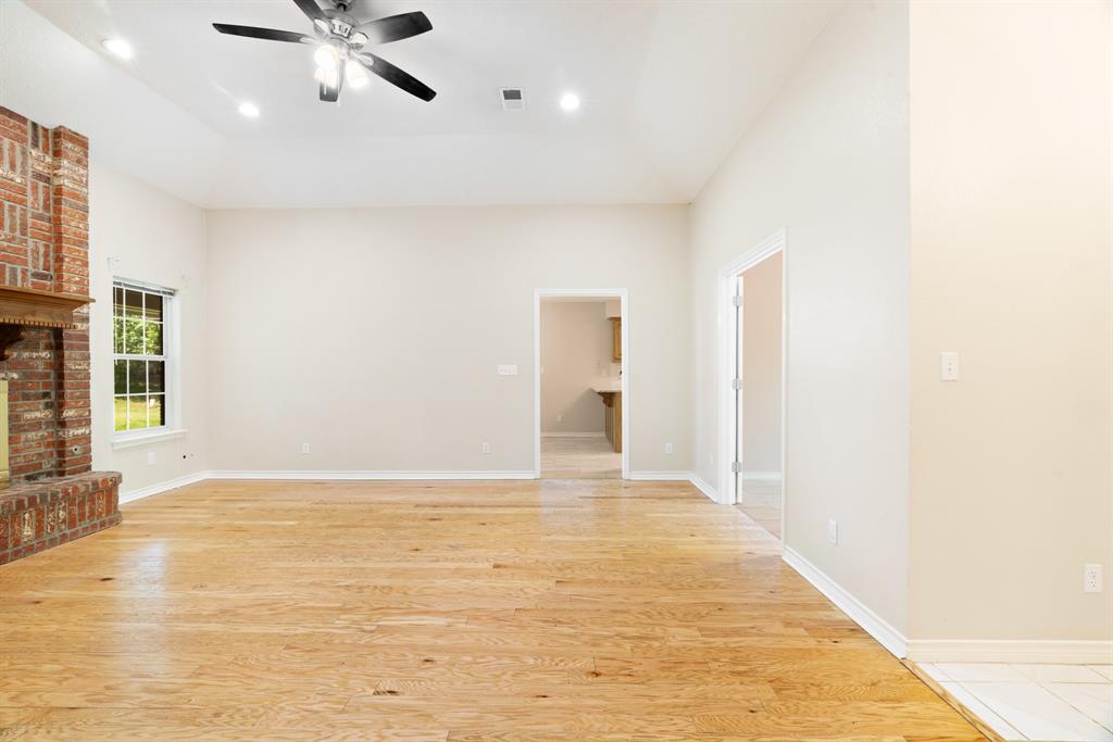 239 Deer Valley Drive Powderly, TX 75473 - Photo 3 of 18 a view of an empty room with window and wooden floor