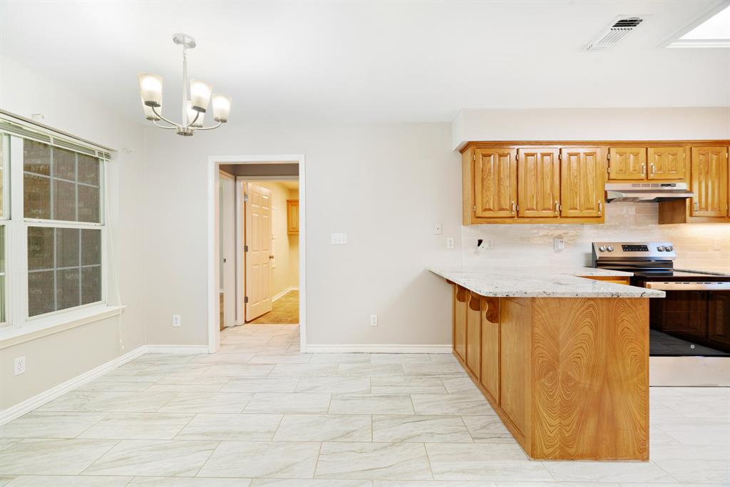 239 Deer Valley Drive Powderly, TX 75473 - Photo 6 of 18 a kitchen with granite countertop a stove a sink dishwasher and a refrigerator with wooden floor