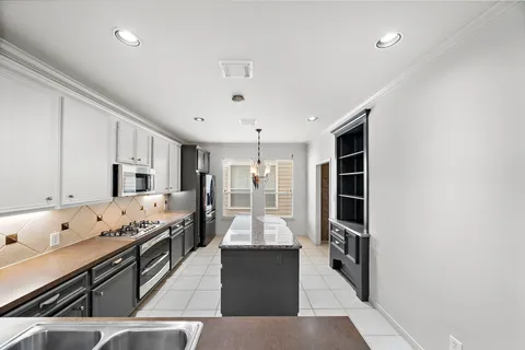 a kitchen with stainless steel appliances granite countertop a stove and cabinets