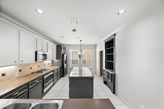 a kitchen with stainless steel appliances granite countertop a stove and cabinets