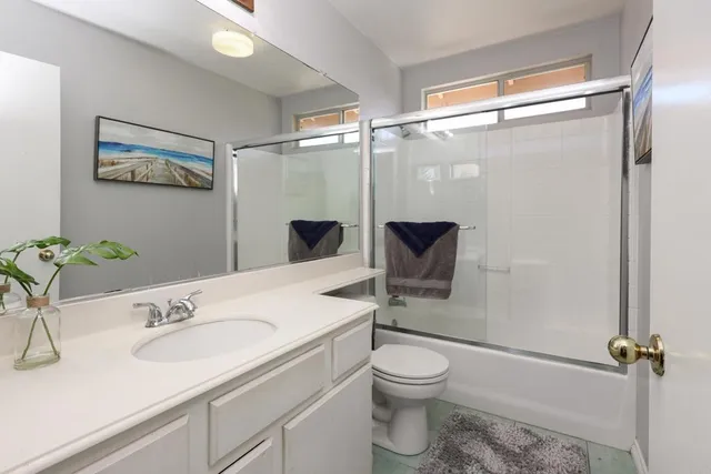 a bathroom with a sink toilet a mirror and shower