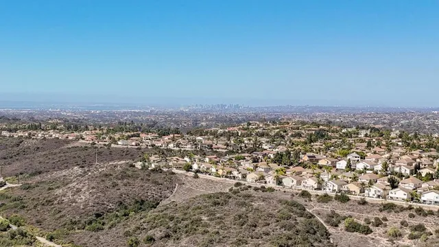an aerial view of house with yard and mountain view in back