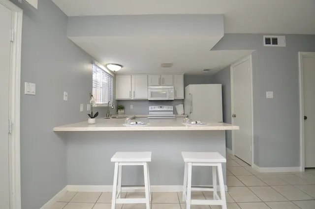 a kitchen with a sink a stove a refrigerator and cabinets