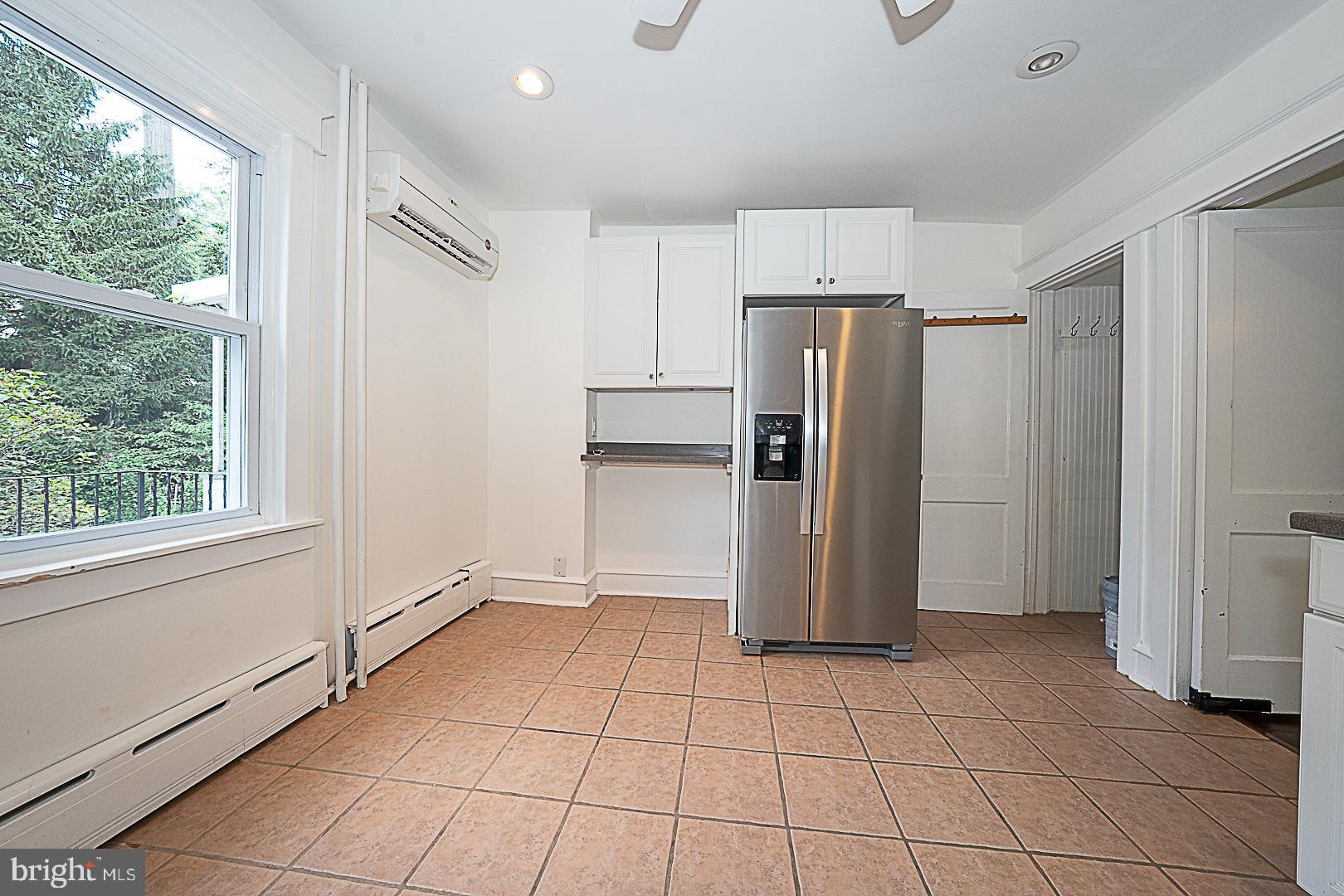 507 Homewood Avenue Narberth, PA 19072 - Photo 14 of 31 a view of a refrigerator in kitchen and an empty room in wooden floor