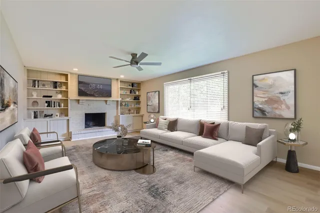 a living room with furniture a fireplace and a large window