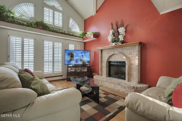 a living room with furniture a fireplace and a large window