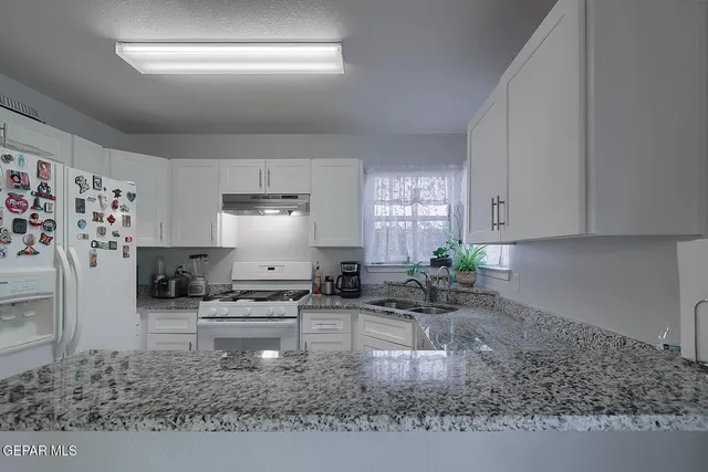 a kitchen with stainless steel appliances granite countertop a sink stove and cabinets