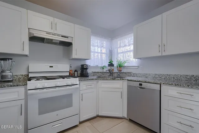 a kitchen with cabinets appliances a sink and a window