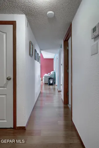 a view of a hallway with wooden floor and stairs