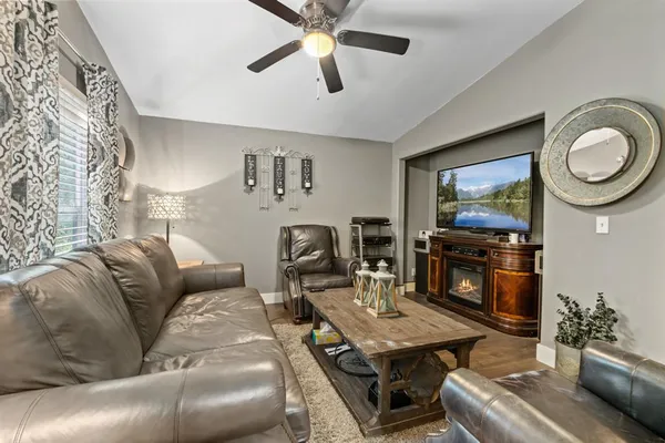 a living room with furniture a flat screen tv and a dining table