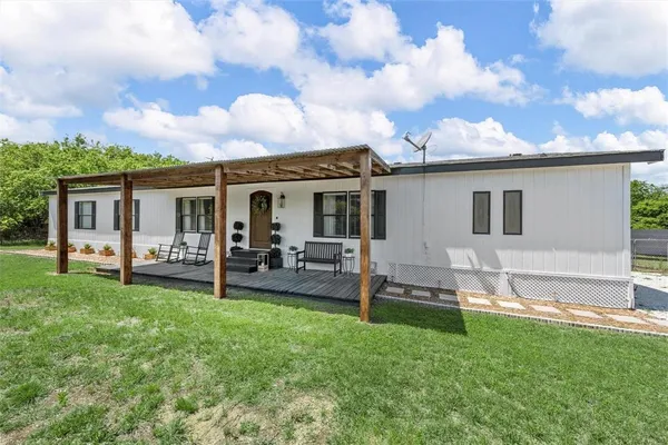 a view of a house with backyard and a tree