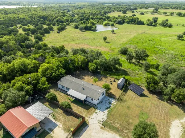 an aerial view of a house with a yard and lake view
