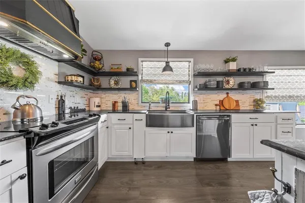a kitchen with stainless steel appliances a stove a sink and cabinets
