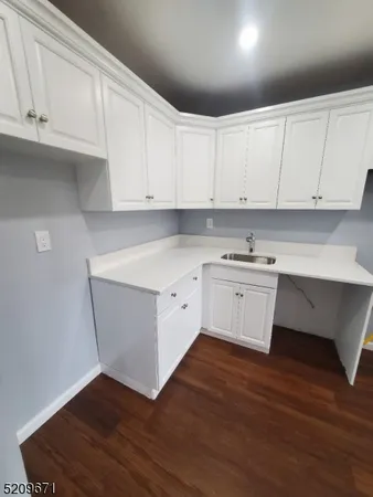 a kitchen with granite countertop white cabinets and white appliances