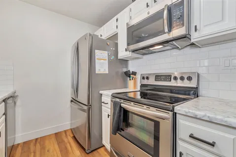 a kitchen with cabinets and steel stainless steel appliances