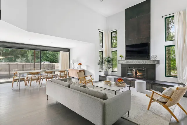 a living room with fireplace furniture and a large window