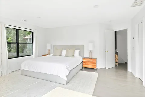 a bedroom with a bed and a window