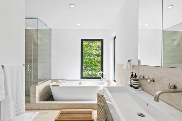 a bathroom with a tub sink and a window