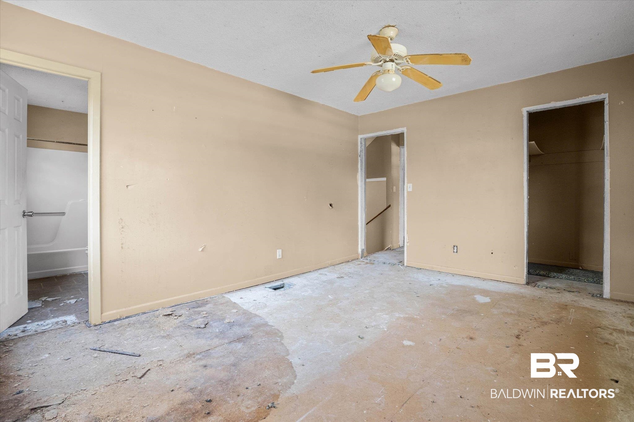 401 Frederick Avenue Fairhope, AL 36532 - Photo 9 of 36 Open interior space featuring a ceiling fan with integrated lighting, multiple doorways, and neutral wall tones