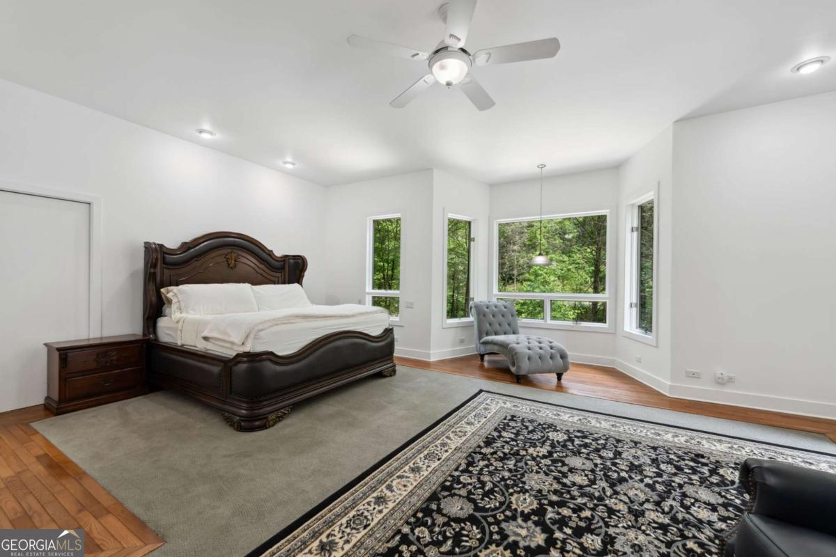 10323 Grassy Mountain Road Ellijay, GA 30540 - Photo 41 of 70 a bedroom with a bed and glass window