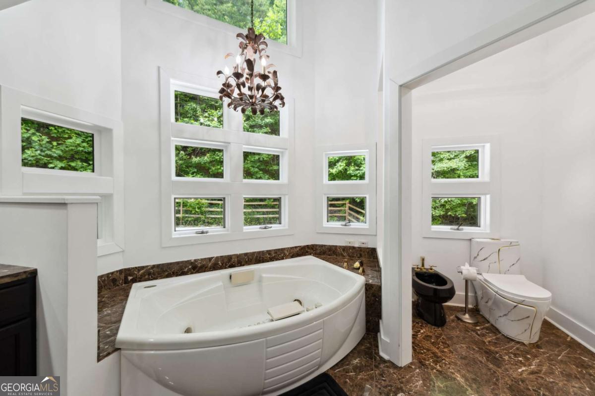 10323 Grassy Mountain Road Ellijay, GA 30540 - Photo 44 of 70 a bathroom with a bathtub and window