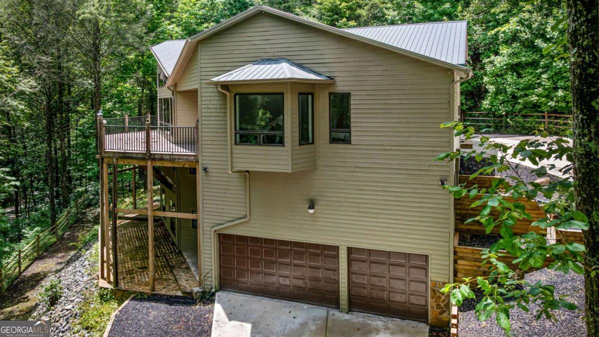 10323 Grassy Mountain Road Ellijay, GA 30540 - Photo 10 of 70 a front view of a house with a garden