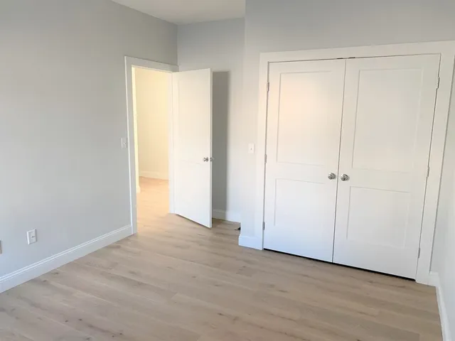 an empty room with wooden floor and a window