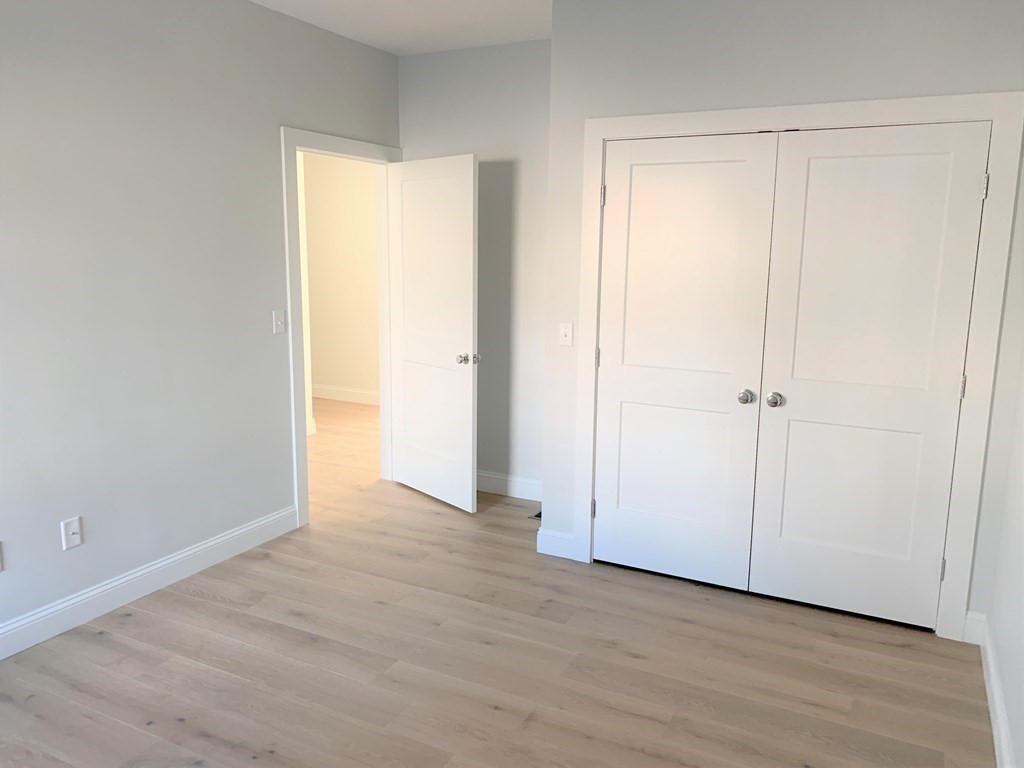 1 Broadway Avenue, Unit 2 Ipswich, MA 01938 - Photo 4 of 8 an empty room with wooden floor and a window