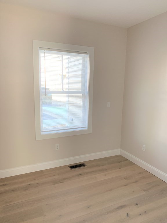 1 Broadway Avenue, Unit 2 Ipswich, MA 01938 - Photo 6 of 8 wooden floor in an empty room with a window