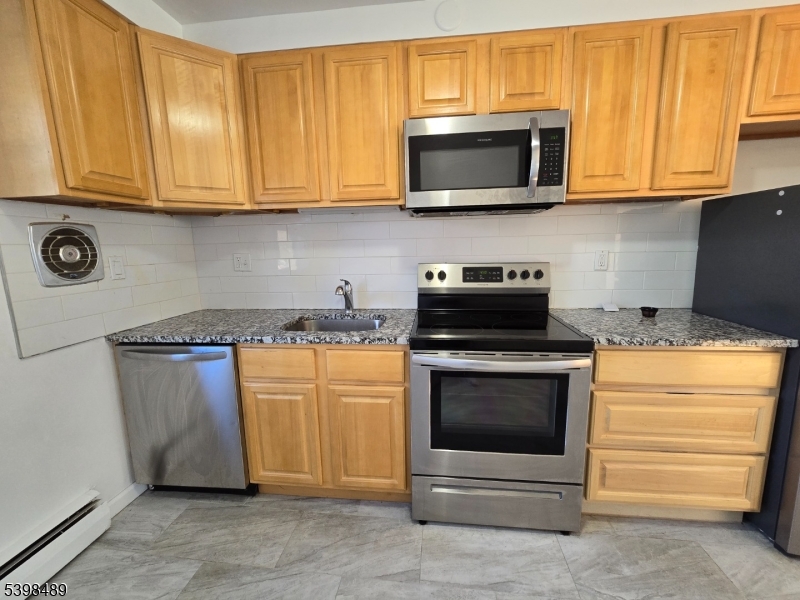 87 Elm Road, Unit 6A Caldwell, NJ 07006 - Photo 3 of 6 a kitchen with stainless steel appliances granite countertop a stove microwave and oven