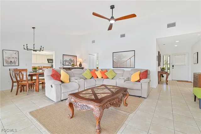 a living room with furniture kitchen view and a chandelier