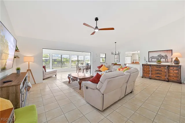 a living room with furniture a flat screen tv and a floor to ceiling window