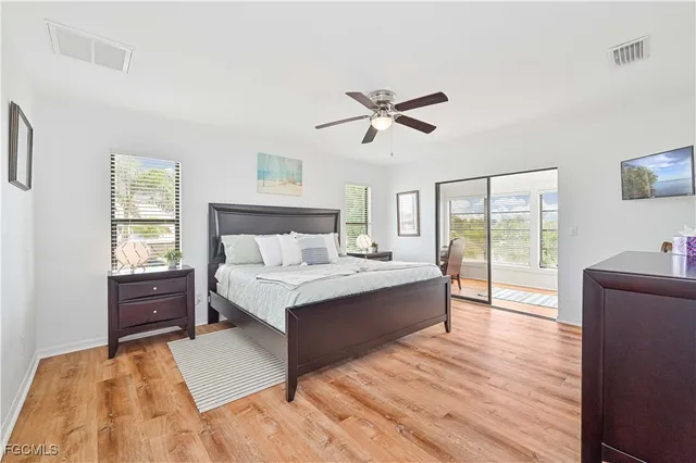 a spacious bedroom with a large bed and a chandelier