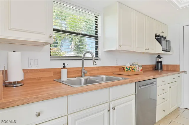a kitchen with a refrigerator and white cabinets