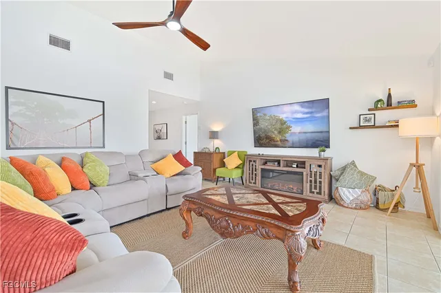 a living room with furniture a rug and a lamp