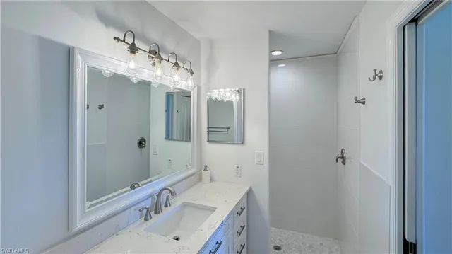 a bathroom with a double vanity sink mirror and shower