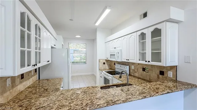 a view of kitchen with stainless steel appliances granite countertop living room