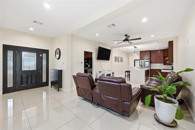 a living room with furniture a flat screen tv and potted plants