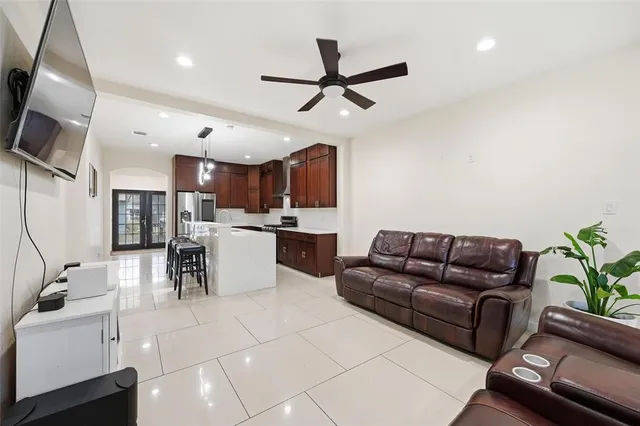 a living room with furniture kitchen view and a chandelier
